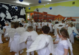 Dzieci przebrane za Anioły tańczą w kole.